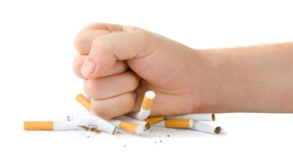 فردی در حال له کردن تعدادی سیگار فردی در حال له کردن تعدادی سیگار