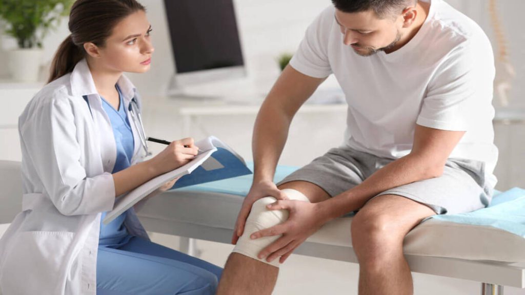 پزشک متخصص در حال معاینه بیماری که زانو درد دارد پزشک متخصص در حال معاینه بیماری که زانو درد دارد