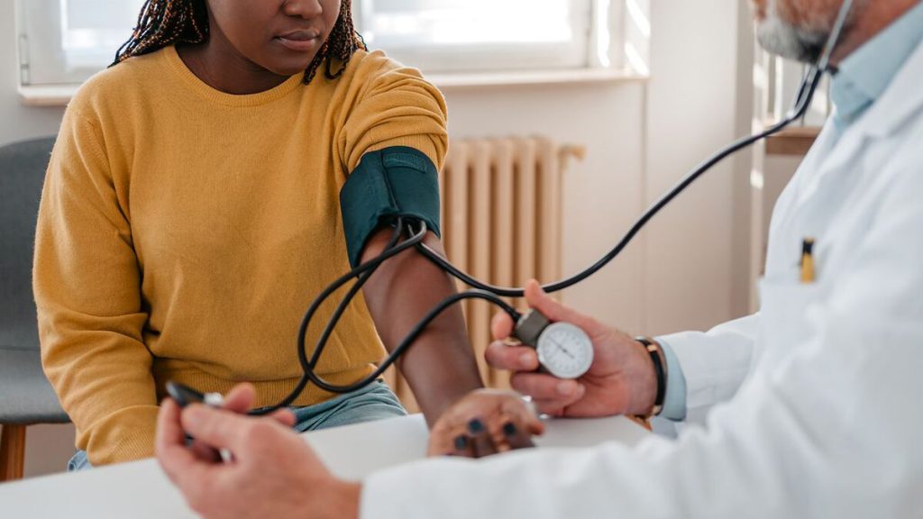 پزشک در حال گرفتن فشار خون بیمار پزشک در حال گرفتن فشار خون بیمار
