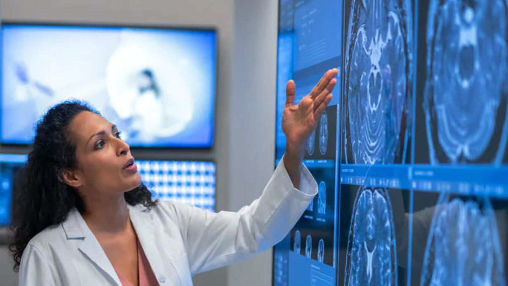 متخصص مغز و اعصاب در حال بررسی عکس مغز بیمار متخصص مغز و اعصاب در حال بررسی عکس مغز بیمار