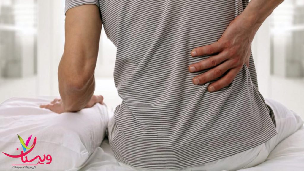 درد دیسک کمر که به شکم می زند مردی که کمر خود را از درد گرفته است