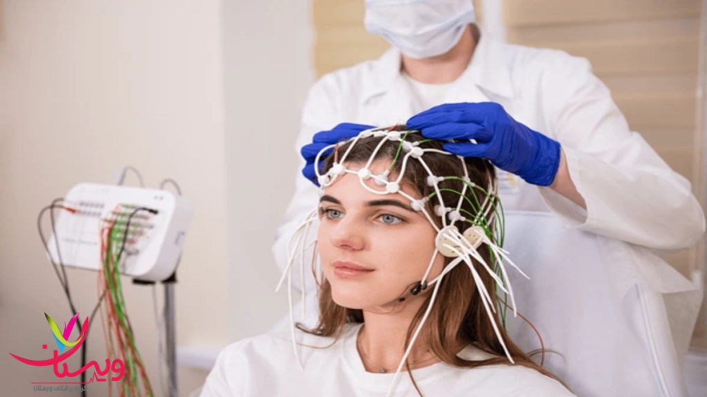 پزشک در حال انجام آزمایش EEG بر روی یک بیمار خانم نشسته است