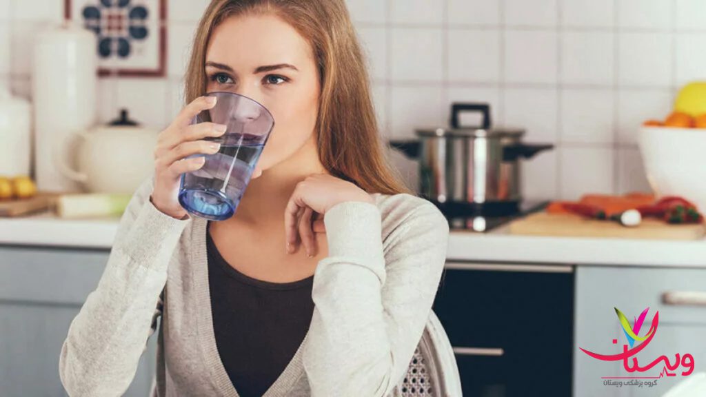 نوشیدن آب برای کاهش التهاب آرتروز زنی که یک لیوان آب مینوشد