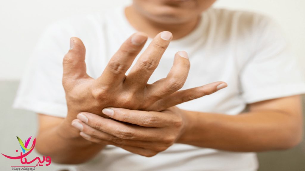 بررسی لرزش دست بهعنوان علامت هشداردهنده پارکینسون مردی که در حال لمس دست خود است بهدلیل احساس لرزش یا بیحسی